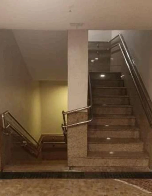 A mesma escada com corrimãos metálicos instalados nas paredes e nos acessos.