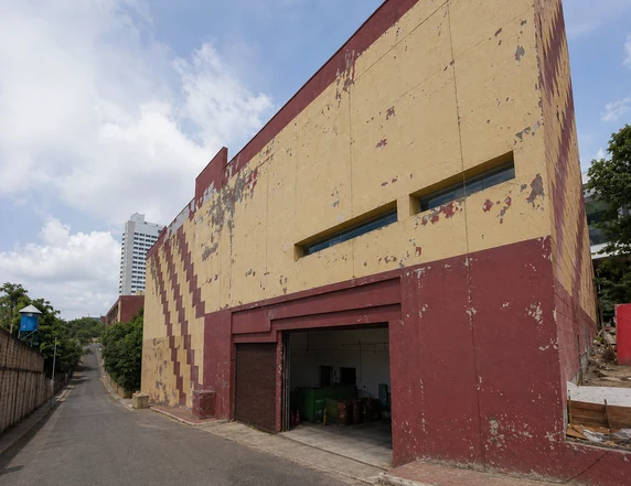 Fachada amarela e vermelha com pintura desgastada antes da revitalização.